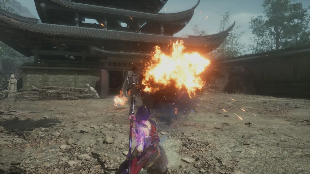 The Wuchang protagonist faces a fiery blast in a traditional temple courtyard.